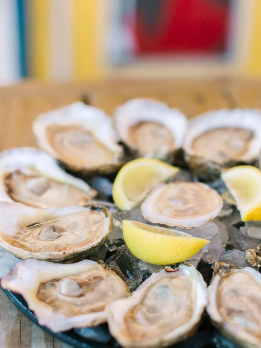Raw oysters on the half shell served with fresh lemon at Hunt's Oyster Bar in Panama City, Florida.
