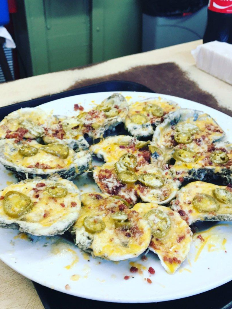 A plate of signature baked oysters topped with cheese, bacon, and jalapeños at Gene's Oyster Bar in Panama City, Florida.