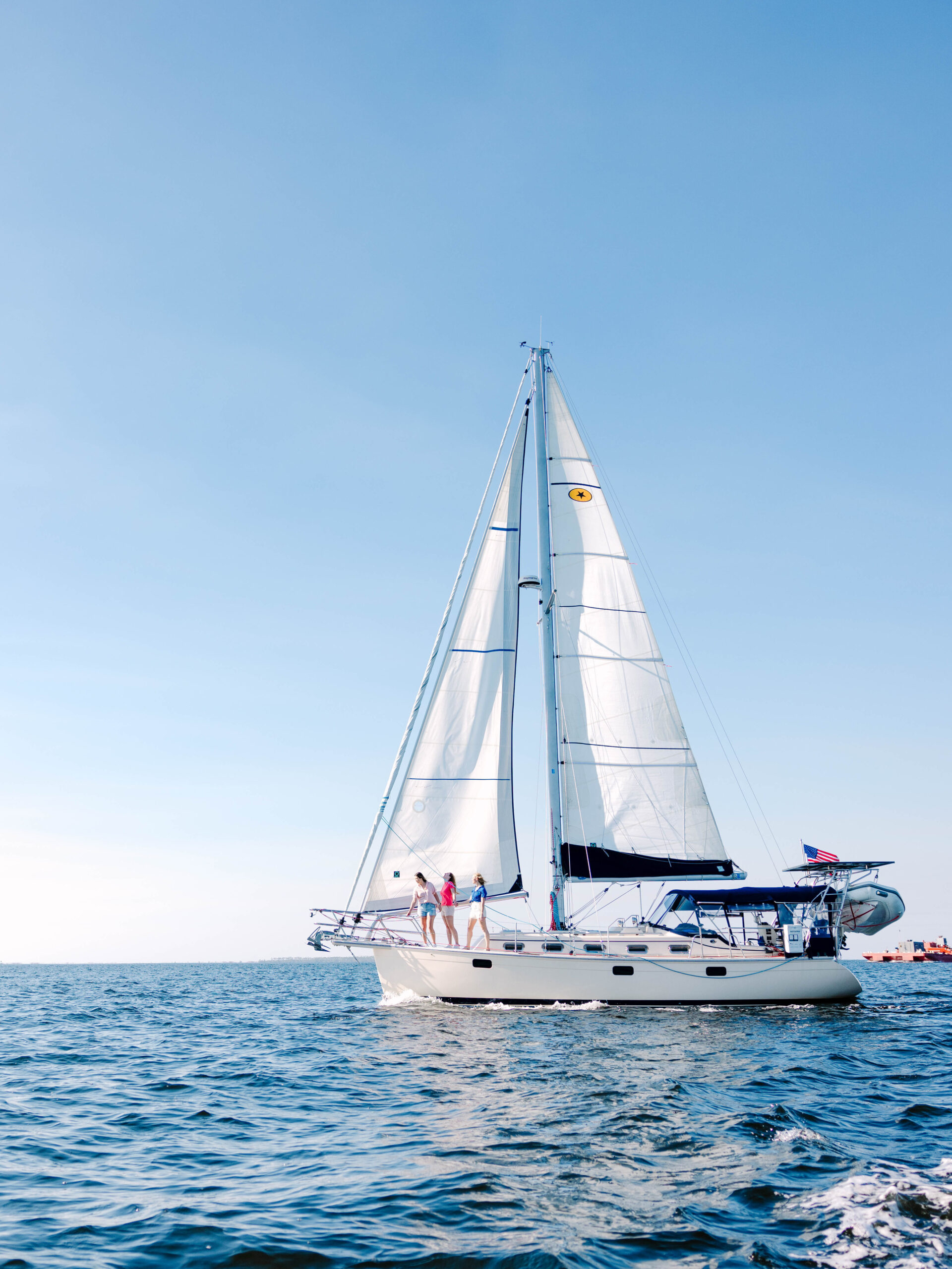 Panama City Sail boat Wide shot of 3 girls out at sea looking into water 2024 Orange Video 1 edited 1 scaled