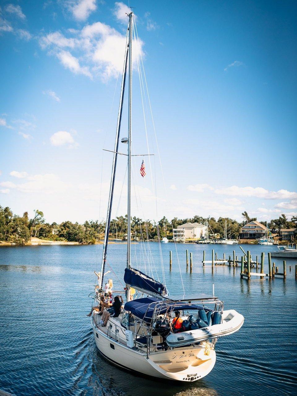 A sailboat gliding through Massalina Bayou at sunset, a perfect relaxing spot in Panama City for a peaceful escape.