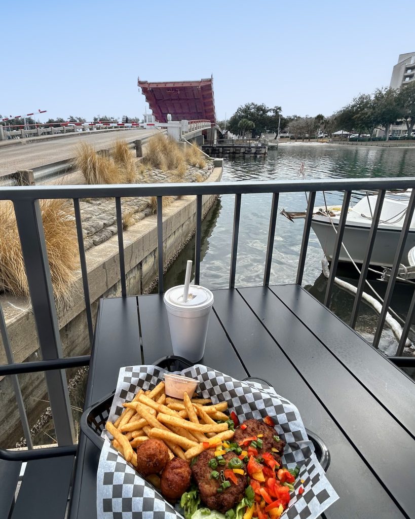 Fresh seafood at Tarpon Dock Seafood Market with St. Andrews Bay in the background, showcasing the sea-to-table experience that defines Florida eco-adventures and sustainable travel in Panama City.