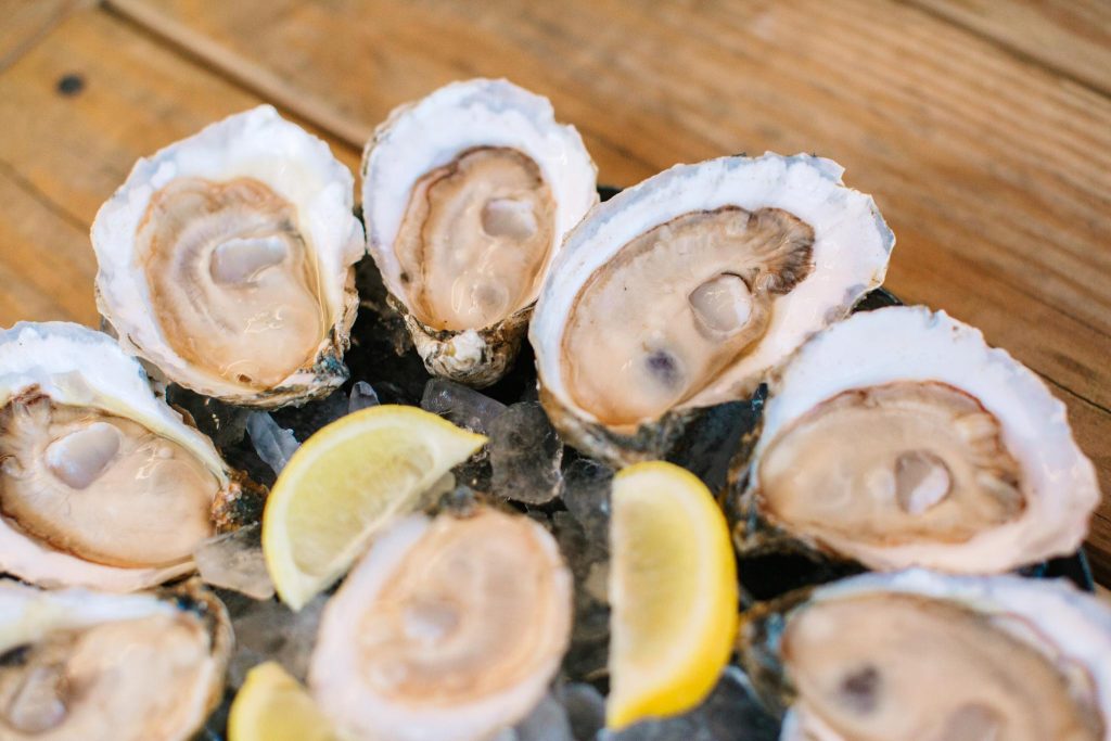 Panama City - Home to World Champions, Historic Marvels, and Rare Natural Wonders in Florida 3 Close-up of a plate of raw oysters on the half shell with lemon wedges, highlighting fresh Gulf seafood and Panama City’s coastal connection to natural wonders in Florida.