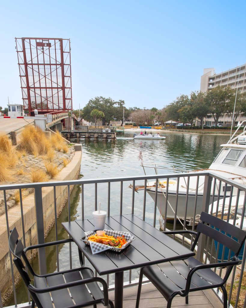 Panama City - Home to World Champions, Historic Marvels, and Rare Natural Wonders in Florida 4 Fresh seafood served at Tarpon Dock Seafood Market with the Tarpon Dock Bridge rising in the background, highlighting local flavor and a view of one of the historic natural wonders in Florida.