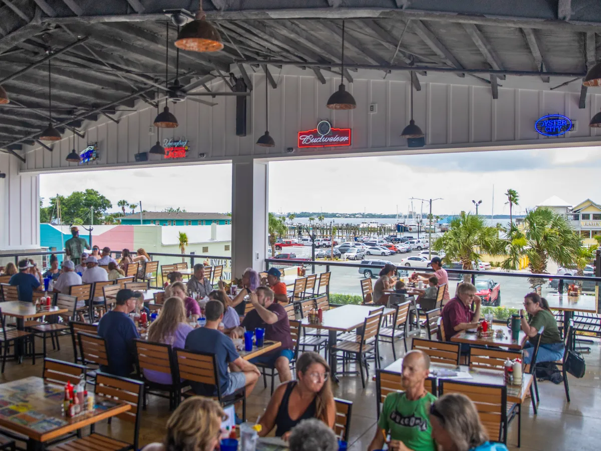 National Oyster Day Shines Bright with the Golden Oyster at Hunt’s Oyster Bar in Panama City, Florida 2 Diners fill the covered patio overlooking St. Andrews Bay at Hunt's Oyster Bar in Panama City, Florida for National Oyster Day in Panama City, Florida