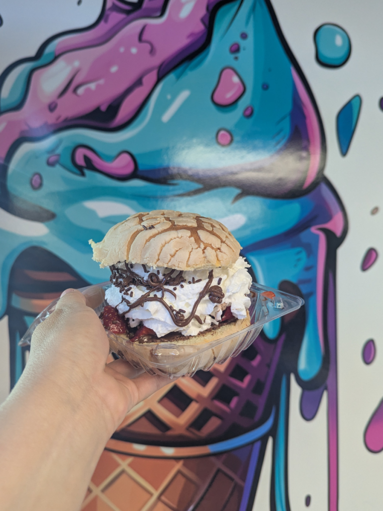 Top 10 Activities for a Family-Friendly Spring Break in Panama City, Florida 13 Ice cream sandwich dessert held in front of a colorful mural during a family-friendly spring break in Panama City.
