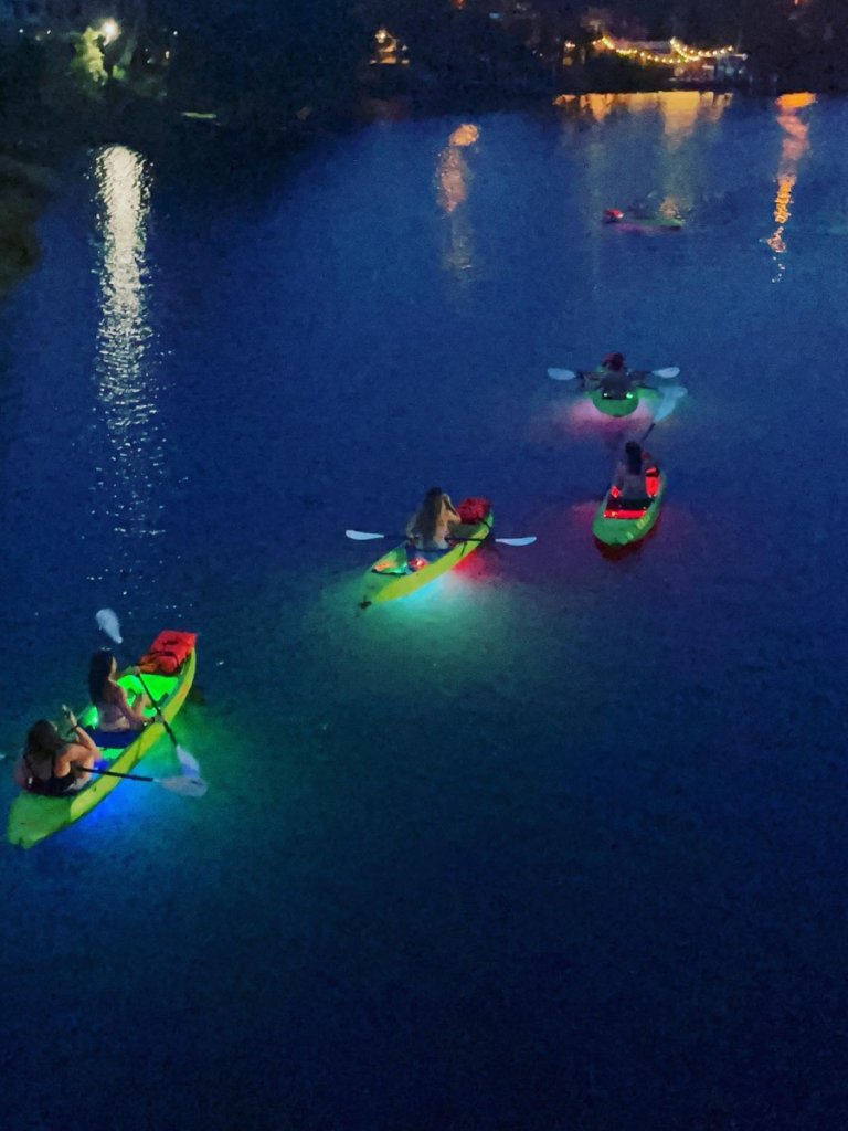 Top 10 Activities for a Family-Friendly Spring Break in Panama City, Florida 20 Group kayaking with glowing LED lights on the water during a family-friendly spring break in Panama City.