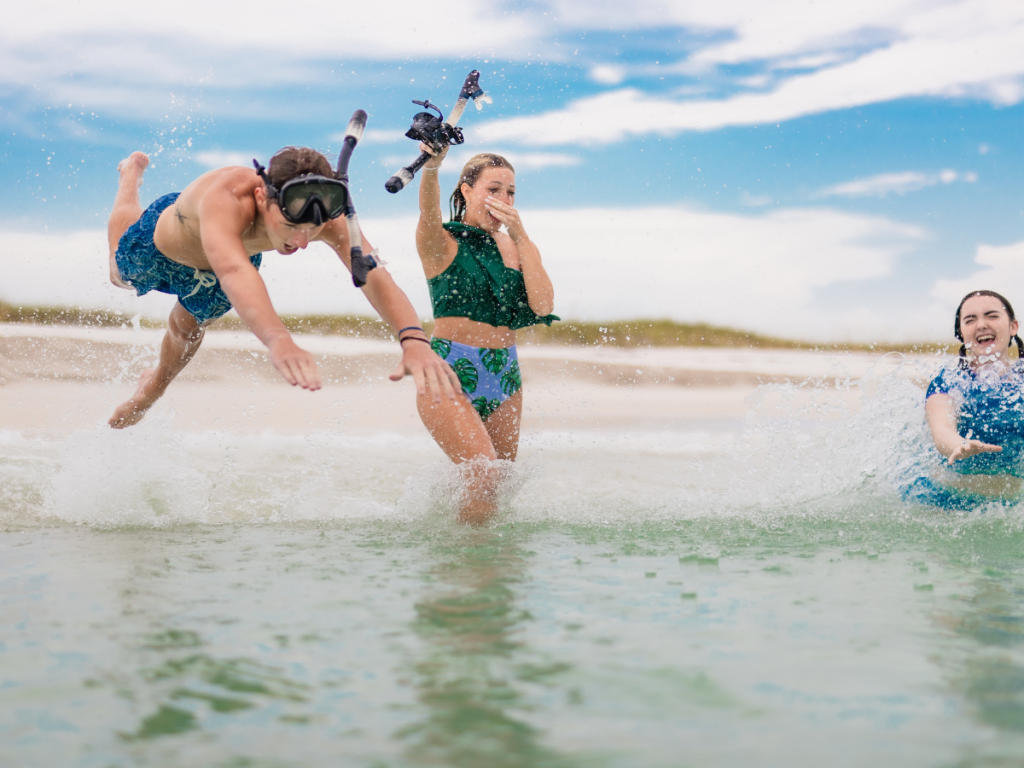 Top 10 Activities for a Family-Friendly Spring Break in Panama City, Florida 3 Kids jumping into clear water while snorkeling and playing along the shoreline during a family-friendly spring break in Panama City.