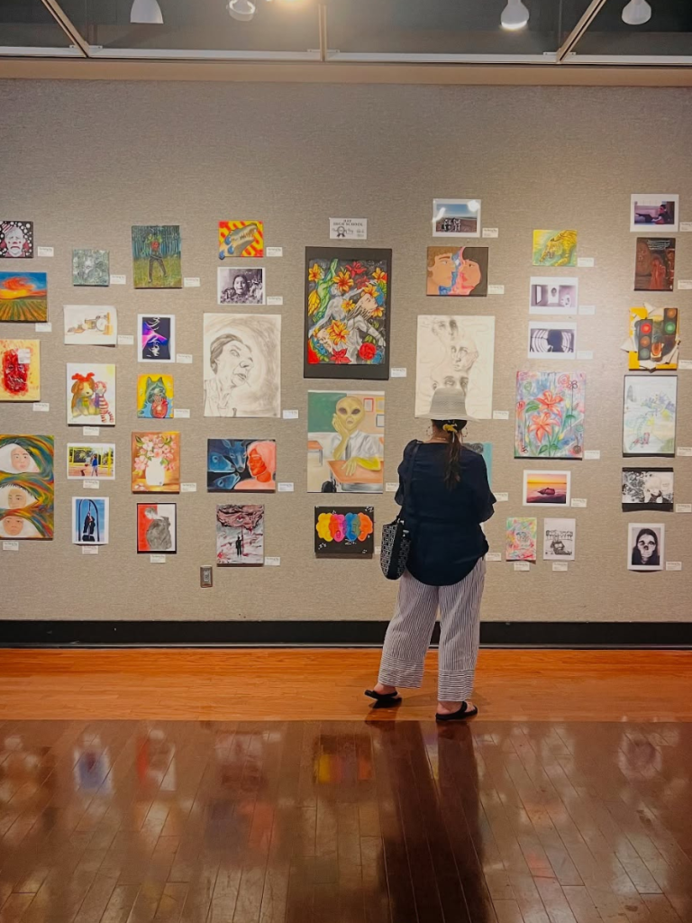 Top 10 Activities for a Family-Friendly Spring Break in Panama City, Florida 5 Visitor viewing colorful artwork inside a local gallery during a family-friendly spring break in Panama City.