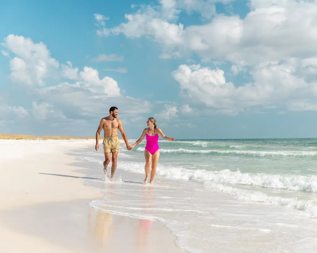 3 Fun Spots for Snorkeling in Panama City, Florida: Where to Go and What to Know 4 Couple walking along the shoreline of Shell Island near clear Gulf waters, a perfect setting for snorkeling in Panama City, Florida.