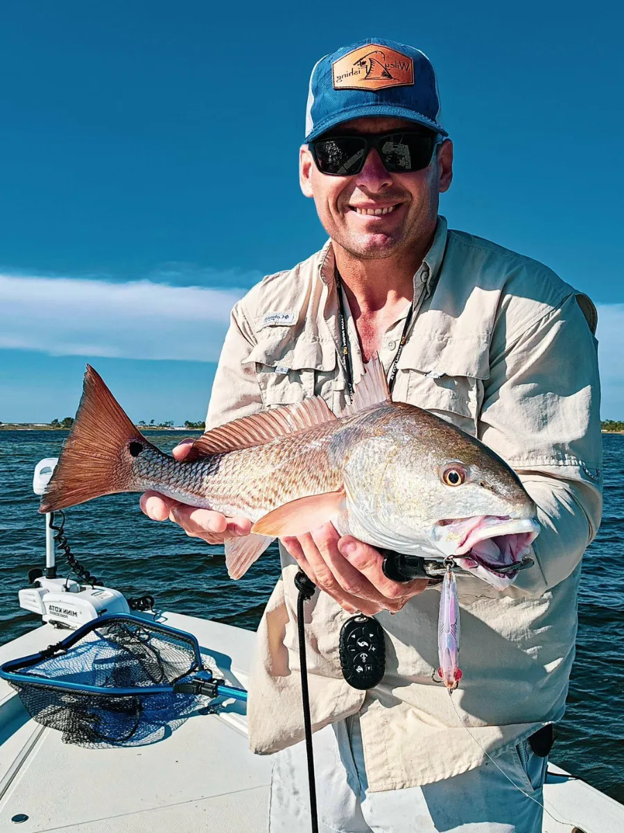 Fishing Seasons in Panama City, Florida: Your Complete Guide to Year-Round Action on the Gulf 2 Angler holding a redfish caught on the flats during inshore fishing seasons in Panama City Florida