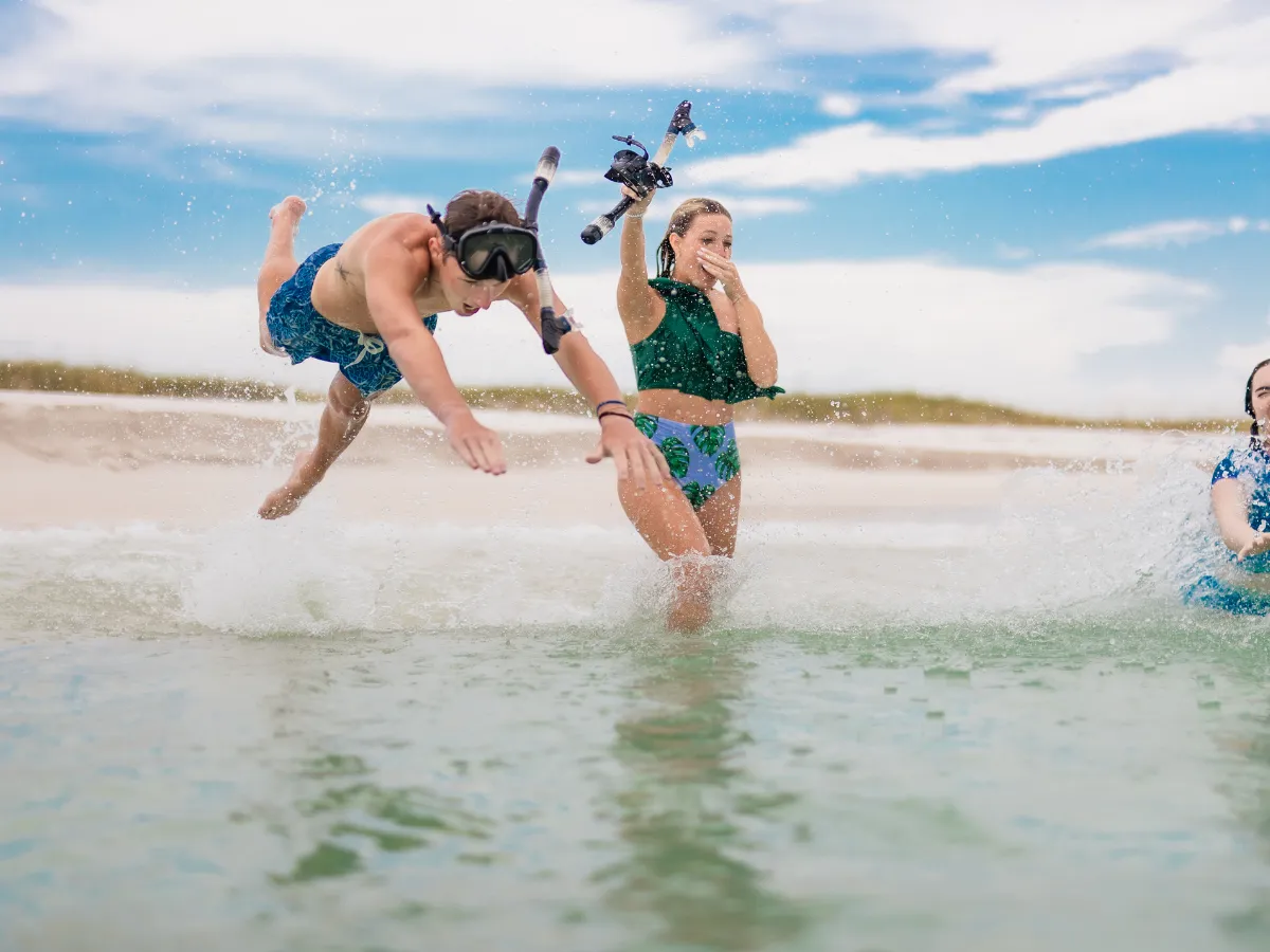 Group jumping into the clear Gulf waters at Shell Island for snorkeling, a top hands-on activity in Panama City Florida