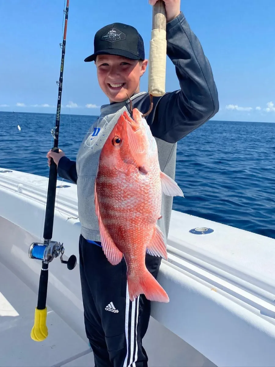 Young angler with a red snapper caught offshore, a memorable skillcation experience in Florida for all ages