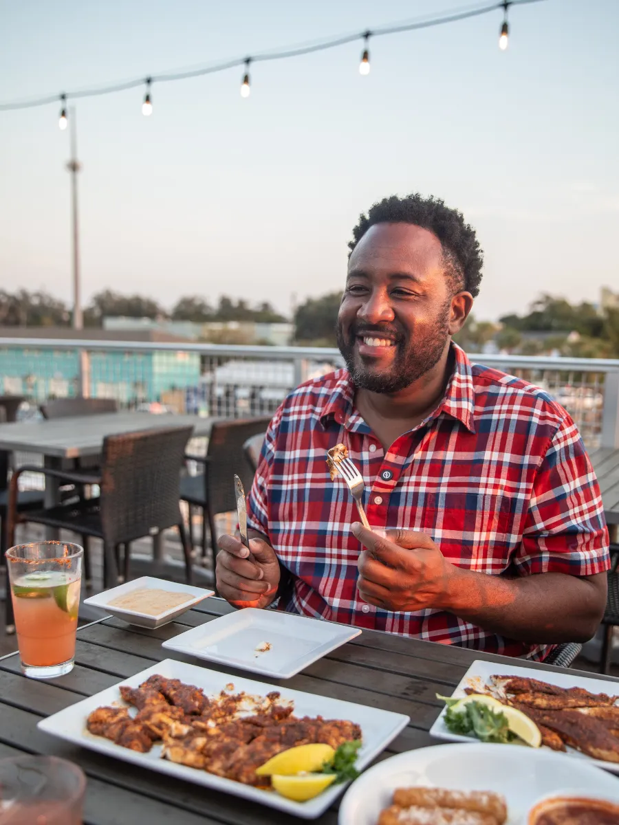 Hook and Cook in Panama City, FL: Where to Bring Your Fresh Catch for Dinner 2 Guest enjoying a fresh Gulf seafood dinner on a waterfront patio, the perfect ending to a hook and cook experience in Panama City FL