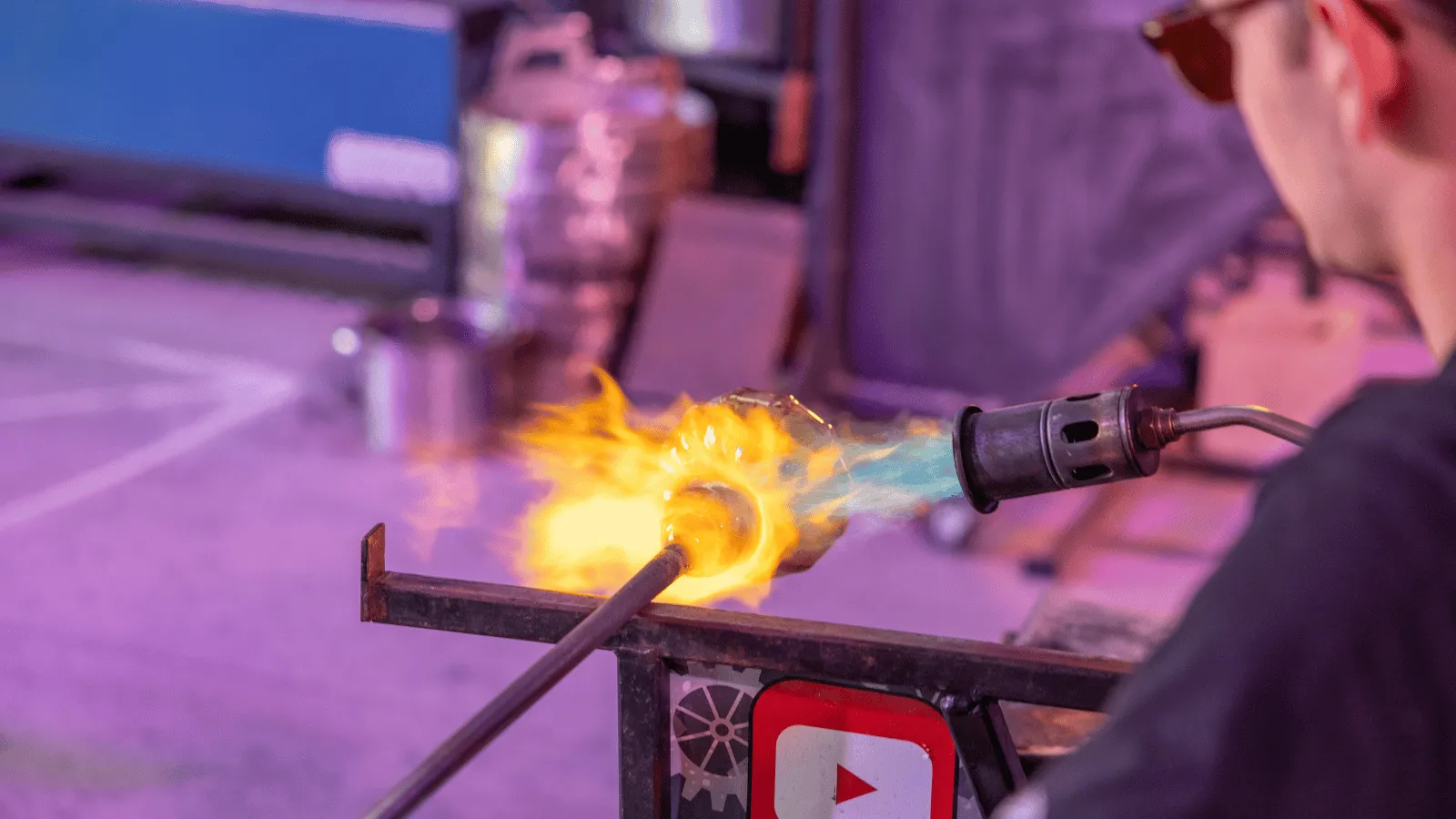 A visitor blowing glass at the Hot Glass Studio during the arts and culture itinerary in Panama City, Florida