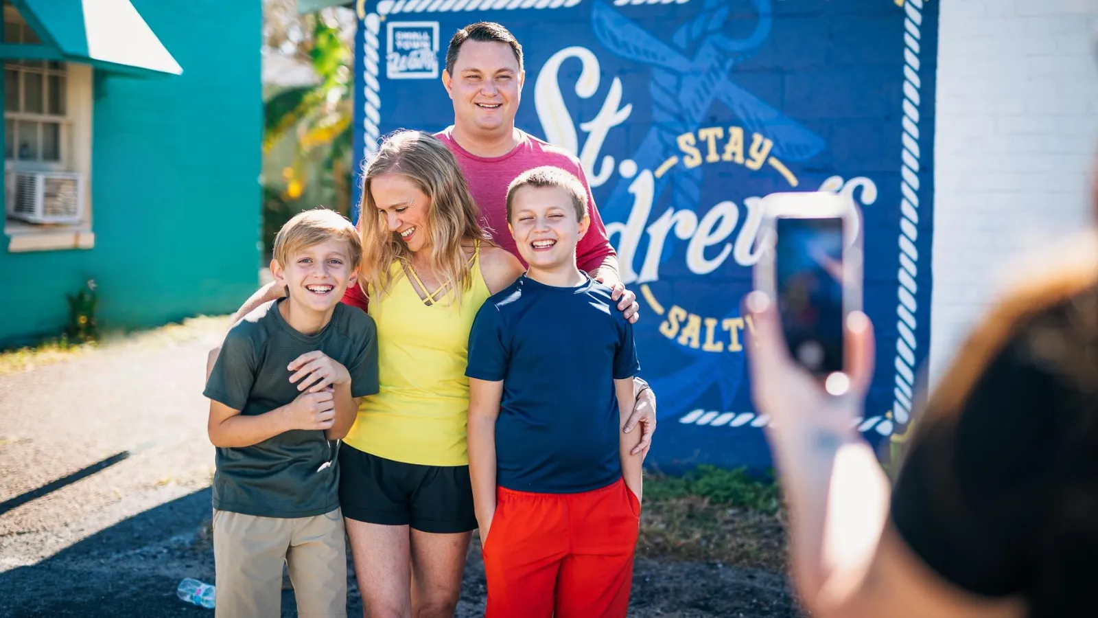 Family taking a photo along the Panama City Mural Trail during a family-friendly itinerary in Panama City, Florida