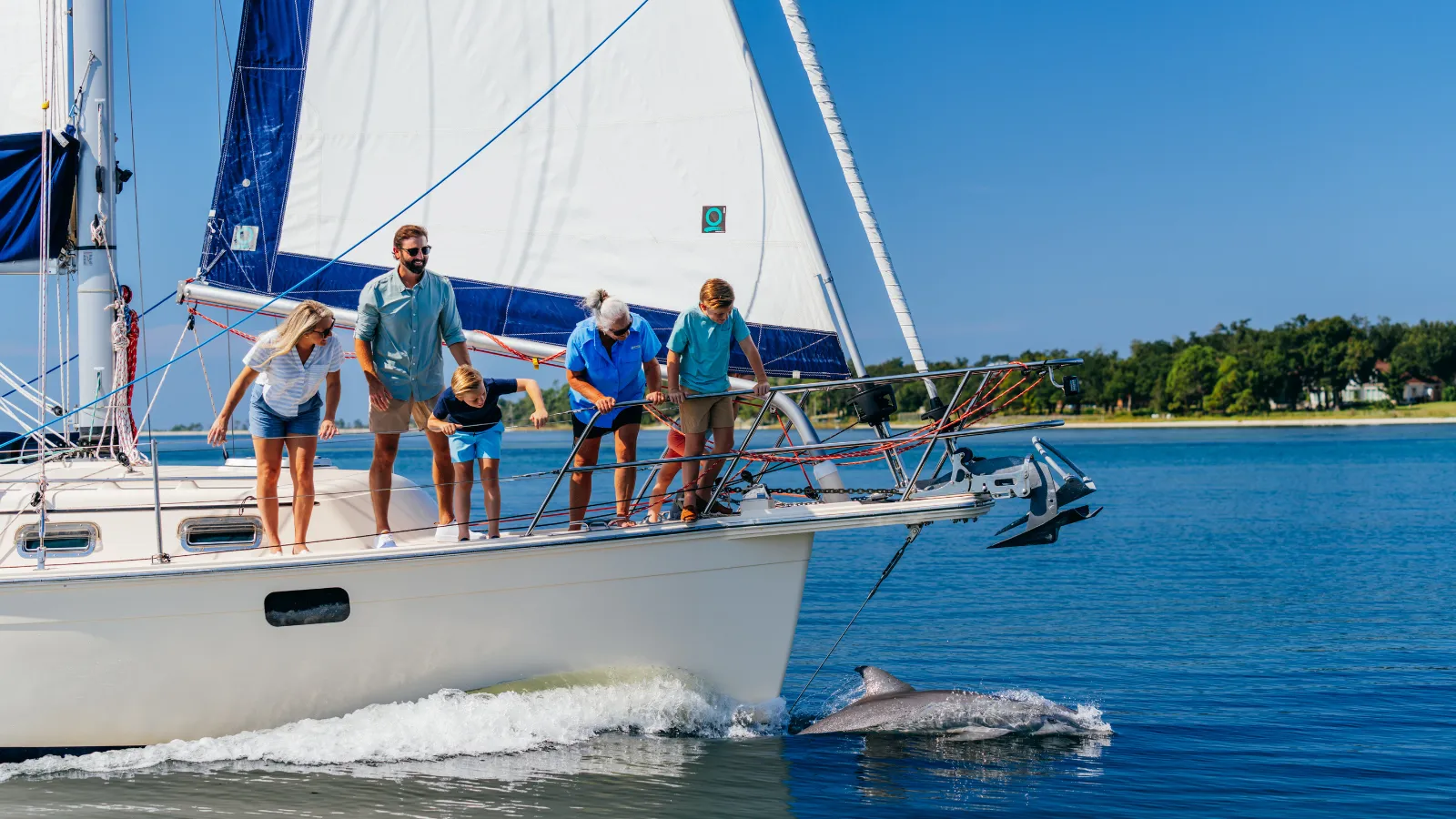 Family sailing with dolphins during a Labor Day itinerary in Panama City, Florida on St. Andrews Bay