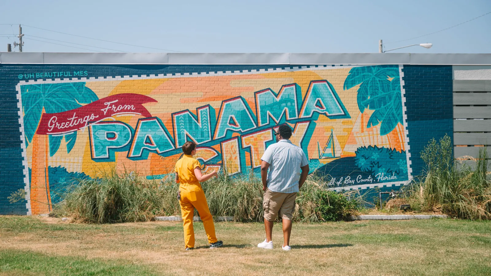Visitors exploring the Panama City postcard mural during a Labor Day itinerary in Panama City, Florida.