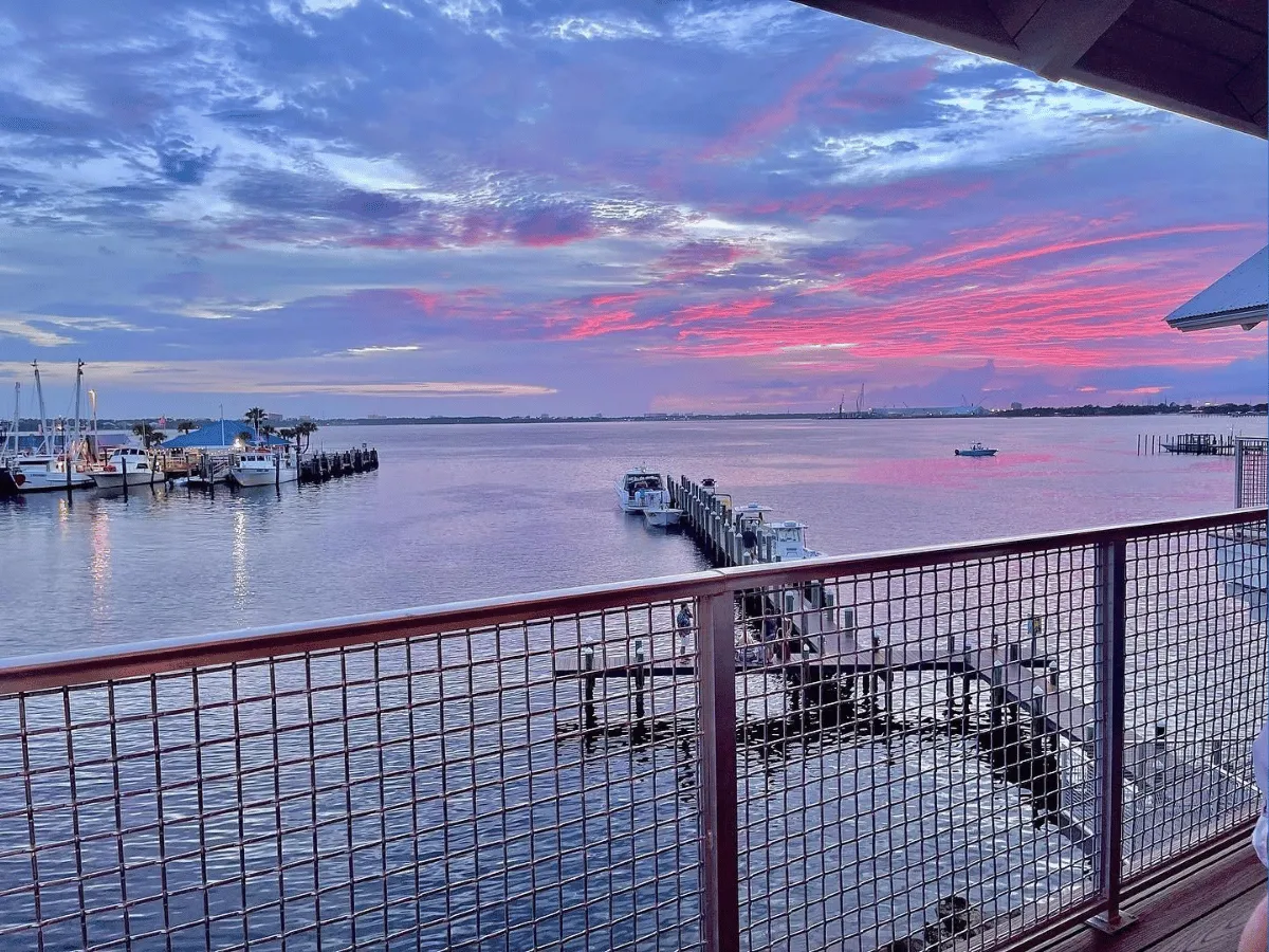 Waterfront marina reflecting colorful evening skies at sunset in Panama City Florida.