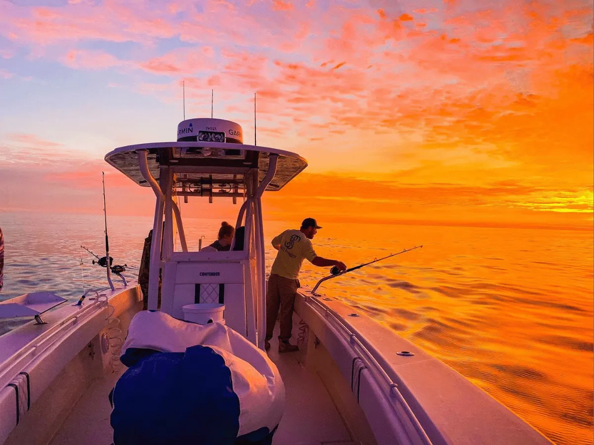 Fishing charter on calm bay waters during a vibrant sunset in Panama City Florida.
