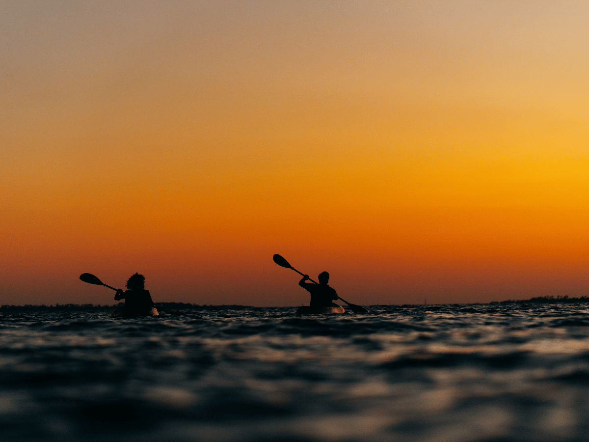 Where to Watch the Best Sunset in Panama City, Florida 18 Kayakers paddling across St. Andrews Bay at sunset in Panama City Florida.